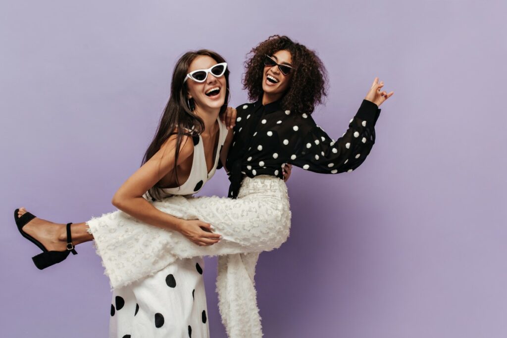 Wonderful Woman Black Blouse Trendy White Pants Laughing Having Fun With Her Friend Sunglasses Isolated Wall 1 1 1024x683